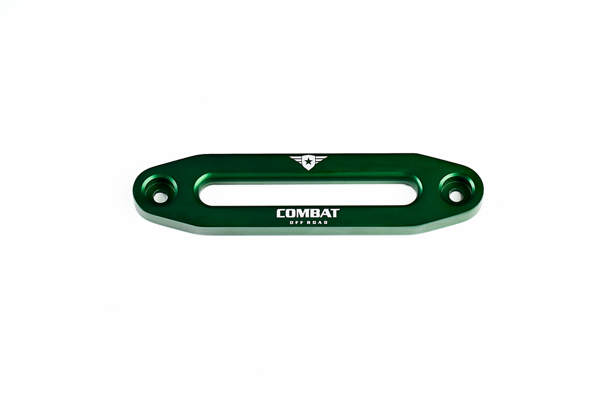 A green aluminum fairlead designed for use with synthetic winch ropes, featuring the Combat Off Road logo engraved in white on the front. The logo includes a shield with a star and winged accents, with the words "Combat Off Road" beneath it. The fairlead has a sleek, durable design with two bolt holes for secure mounting on Jeep bumpers.