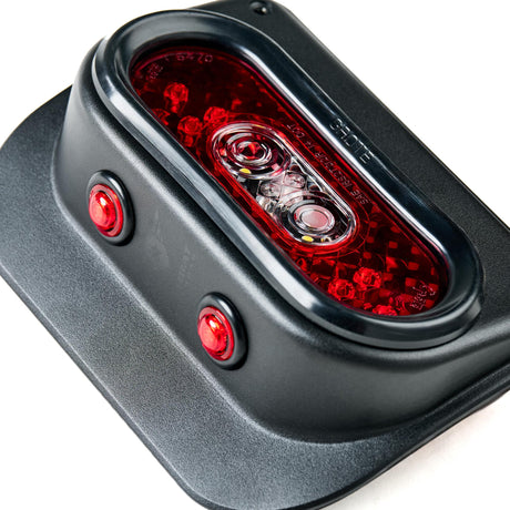 Close-up of a Tail Gunner Tail Light designed for a Jeep JK. The light is housed in a black aluminum casing with a red LED main light and two red side markers. The central light features a reflective red lens with visible LED elements, ensuring high visibility and compliance with safety standards. The smooth black finish of the housing highlights the durable and premium construction of the tail light assembly.