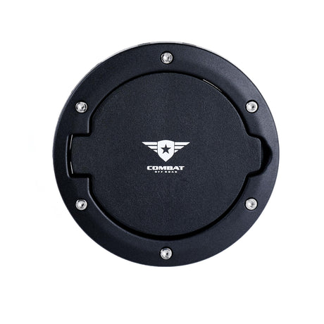 A black Combat Off Road fuel door cover for Jeep JK, featuring a textured finish and the Combat Off Road logo in white at the center. The cover is accented with stainless steel bolts around the perimeter, combining rugged style with durability. Designed as a functional and aesthetic upgrade for the fuel compartment.