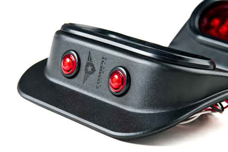 Close-up side view of a Tail Gunner Tail Light for Jeep JK, showcasing the black aluminum housing and two bright red side marker lights. The Combat Off Road logo is laser-etched on the housing, emphasizing the brand's identity. The smooth power coat finish enhances durability and adds a sleek, modern appearance. The wiring is visible underneath, ready for installation.