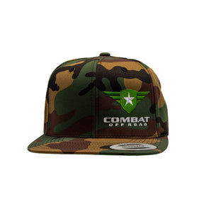 A camouflage-patterned snapback hat featuring the Combat Off Road logo embroidered on the front. The logo includes a green shield with a white star and winged accents, with the words "Combat Off Road" in bold white letters below. The hat has a flat brim and a sticker on the front indicating its adjustable fit.