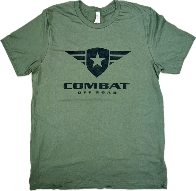 A green t-shirt featuring the Combat Off Road logo printed in black on the chest. The logo includes a shield with a star and winged accents, with the words "Combat Off Road" in bold black letters underneath. The shirt has a crewneck design and short sleeves, offering a comfortable and casual style.