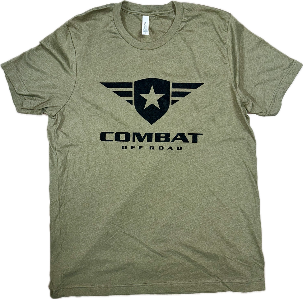 A olive t-shirt featuring the Combat Off Road logo printed in black on the chest. The logo includes a shield with a star and winged accents, accompanied by the text "Combat Off Road" in bold black letters underneath. The shirt has a crewneck design and short sleeves, offering a classic and comfortable fit.